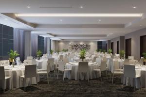 un salón de banquetes con mesas y sillas blancas en AC Hotel by Marriott Washington DC Capitol Hill Navy Yard, en Washington