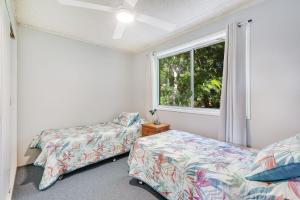 a bedroom with two beds and a window at Skyline Unit 12 in Gold Coast