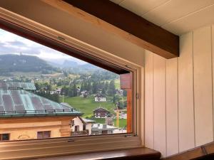 ventana con vistas a la montaña en Mansarda nel centro di Cortina, en Cortina dʼAmpezzo