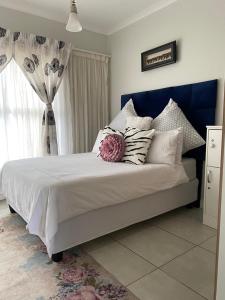 a bedroom with a bed with pillows and a window at Tranquil Gateways-The blyde crystal lagoon in Pretoria