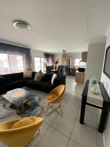 a living room with a black couch and a table at Tranquil Gateways-The blyde crystal lagoon in Pretoria