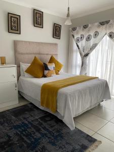 a bedroom with a large bed and a window at Tranquil Gateways-The blyde crystal lagoon in Pretoria