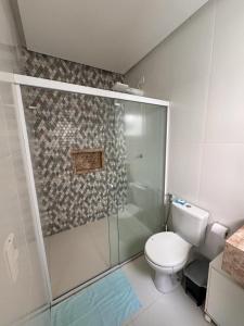 La salle de bains est pourvue de toilettes et d'une douche en verre. dans l'établissement Casa com 3 quartos e piscina - 8 min da Praia, à São José de Ribamar