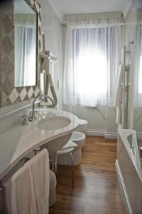 ヴェローナにあるホテル ヨーロッパのバスルーム(洗面台、トイレ、鏡付)