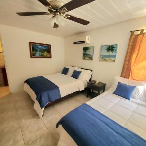 a bedroom with two beds and a ceiling fan at Hotel Villa Prats in Manuel Antonio