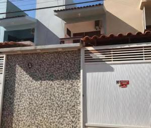 a building with a white garage door and a fence at Casa lagoa do pau- coruripe/AL - 300 metros da praia in Coruripe