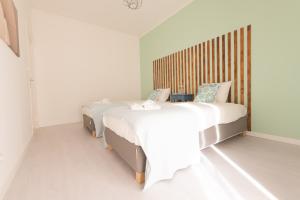 オエイラスにあるOeiras Sweet Flatのベッドルーム1室(ベッド2台、木製ヘッドボード付)