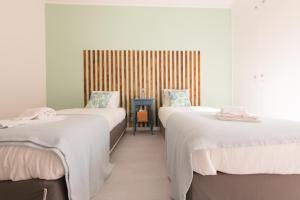 オエイラスにあるOeiras Sweet Flatの白い壁の客室内のベッド2台