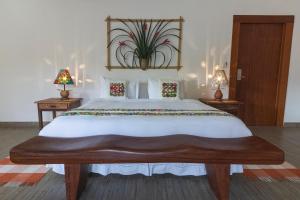 a bedroom with a large white bed with two lamps at Resort Fazenda 3 Pinheiros in Engenheiro Passos