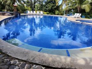 - une grande piscine d'eau bleue dans un complexe dans l'établissement Villa, KOCORU Casa de campo y playa, à Puntarenas
