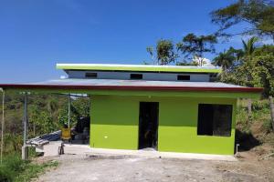 une maison verte avec un toit rouge dans l'établissement Villa, KOCORU Casa de campo y playa, à Puntarenas
