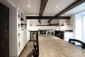 uma cozinha com uma longa mesa de madeira e cadeiras em Lodge am Oxenweg - Zimmer 5 em Husum