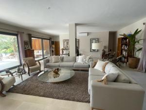 a living room with couches and a coffee table at Villa YEMAYA - Villa d'hôtes in Ngaparou