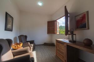 a living room with chairs and a desk and a window at Resort Fazenda 3 Pinheiros in Engenheiro Passos