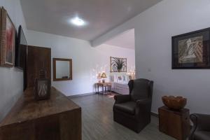 a living room with a chair and a bed at Resort Fazenda 3 Pinheiros in Engenheiro Passos