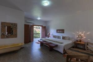 a bedroom with a bed and a bathtub and a tub at Resort Fazenda 3 Pinheiros in Engenheiro Passos