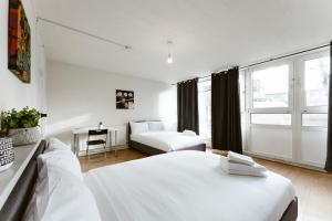 - une chambre blanche avec un lit et un canapé dans l'établissement Langdon Park Room, à Londres 18 autres photos