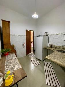 een keuken met een koelkast en een tafel. bij Casa Teresa in Rio de Janeiro