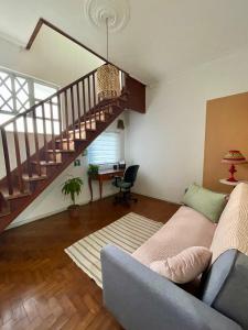 a living room with a couch and a staircase at Casa Teresa in Rio de Janeiro