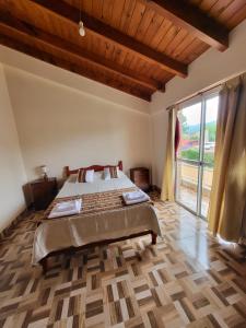 ein Schlafzimmer mit einem Bett und einem großen Fenster in der Unterkunft La Glorieta -Casas de descanso in San Salvador de Jujuy + 100 Fotos