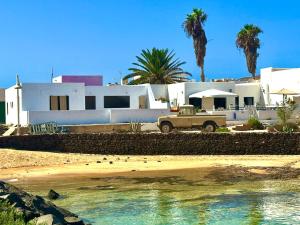 un camión estacionado frente a una casa con palmeras en SONRYE Graciosa, en Caleta de Sebo
