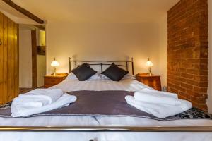 - une chambre avec un lit et des serviettes dans l'établissement 14th-century cosy 3-bed cottage Business stays, à Bloxham