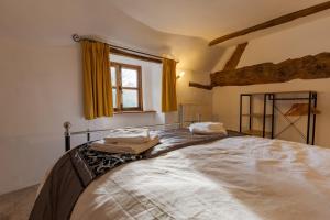- une chambre avec un grand lit et des serviettes dans l'établissement 14th-century cosy 3-bed cottage Business stays, à Bloxham