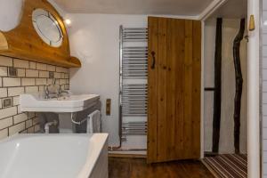 La salle de bains est pourvue d'un lavabo et d'un miroir. dans l'établissement 14th-century cosy 3-bed cottage Business stays, à Bloxham