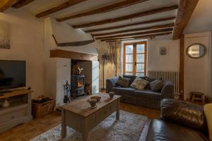 ein Wohnzimmer mit einer Couch und einem Couchtisch in der Unterkunft 14th-century cosy 3-bed cottage Business stays in Bloxham
