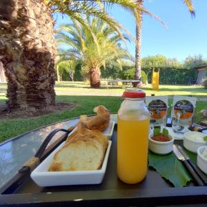 a tray with a plate of bread and a bottle of orange juice at La Vieja Finca in Ciudad Lujan de Cuyo