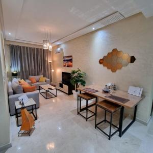 Luxury Appartement Guesshouse في طنجة: غرفة معيشة مع طاولة وأريكة