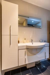uma casa de banho branca com um lavatório e um frigorífico em Luxury Penthouse In Central London em Londres