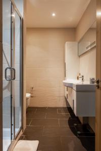 uma casa de banho com um chuveiro, um lavatório e um WC. em Luxury Penthouse In Central London em Londres