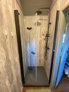 a shower with a glass door in a bathroom at Spring Grounds Farm Shepherd Huts 