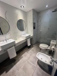 a bathroom with two sinks and a toilet and a mirror at 4919 SOHO LIVE - Palermo Soho Apartments in Buenos Aires
