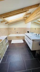 a bathroom with two sinks and a bath tub at Kohlis Alpine Home in Bruck an der Großglocknerstraße