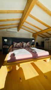 uma cama grande no meio de um quarto em Kohlis Alpine Home em Bruck an der Großglocknerstraße