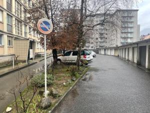 un panneau sur le côté d'une rue avec des voitures garées dans l'établissement T4 spacieux tout confort / parking gratuit, à Grenoble