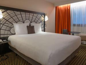 a large white bed in a hotel room at Mercure Paris Porte De Versailles Expo in Paris