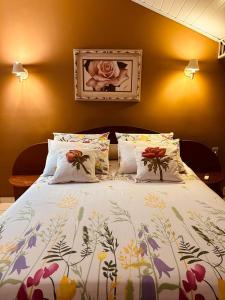 um quarto com uma cama com colcha floral em POUSADA NAO ME DEIXES em Paty do Alferes