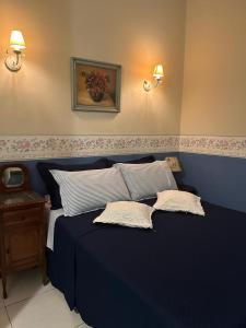 um quarto com uma cama azul e 2 almofadas em POUSADA NAO ME DEIXES em Paty do Alferes