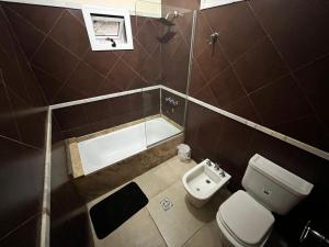 a bathroom with a toilet and a bath tub at Departamento Romano’s in Santiago del Estero