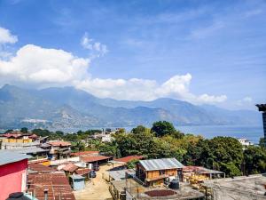 a town with a view of the water and mountains at Joyas Del Sol Hotel in San Pedro La Laguna
