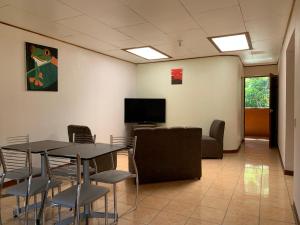 a room with a table and chairs and a tv at Globi Lodge #5 in Monteverde Costa Rica