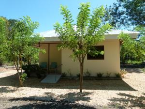een klein huisje met een boom ervoor bij Jardines del Golfo in Lepanto