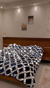 ein Bett mit einer schwarzen und weißen Bettdecke darauf in der Unterkunft A luxury apartment full furnished ultra modern in Kairo