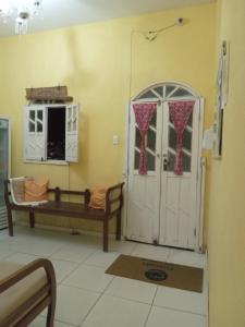 Zimmer mit einer Tür, einer Bank und einem Fenster in der Unterkunft Pousada Villas Colossos in Lençóis