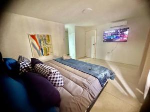 Un dormitorio con una cama grande con almohadas. en Amplio apartamento renovado con 3 habitaciones, 3 baños, terrazas, Smart TV y wifi incluidos en Caracas