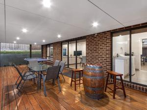 a patio with a table and chairs and a barrel at 11a Railway Parade Wandin North in Wandin North