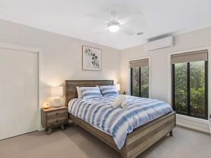 Wandin North11a Railway Parade Wandin North的卧室里有一张床，床铺有蓝白相间的被子